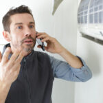 Repairman,Contractor,On,The,Phone,Fixing,A,Heating,Panel,Problem